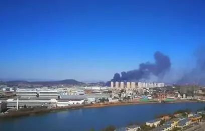倉(cāng)庫(kù)里往外冒著滾滾黑煙，把周圍的天空染上烏黑色。